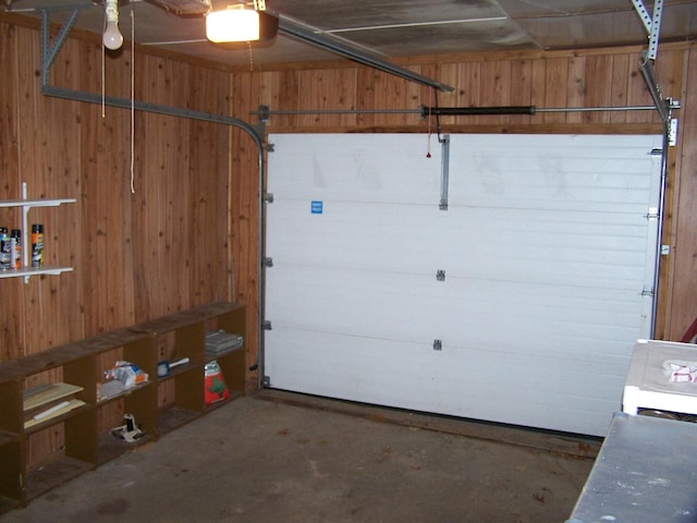 garage with a garage door opener and wooden walls