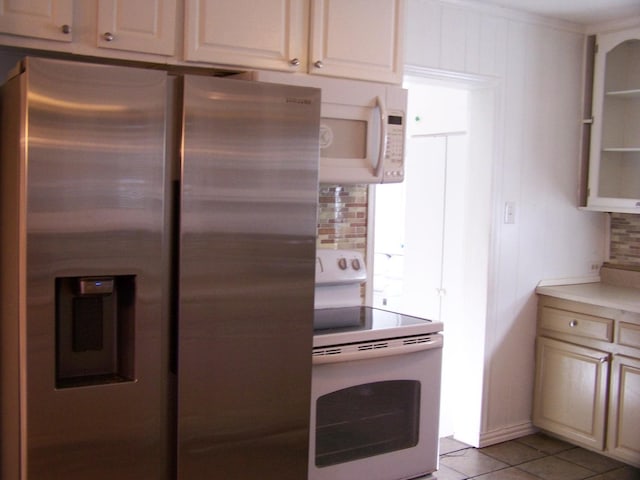 kitchen with light tile patterned flooring, white appliances, and decorative backsplash