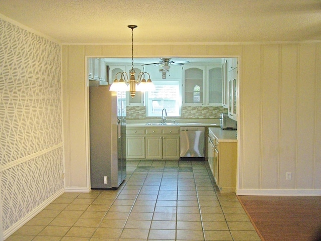 kitchen featuring pendant lighting, stainless steel appliances, crown molding, and sink