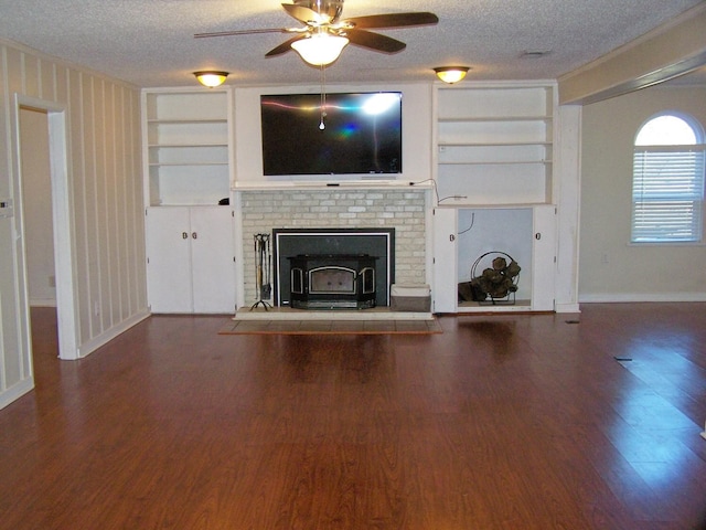 unfurnished living room with wood-type flooring, built in features, and a textured ceiling