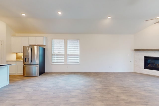 5204 Edge Way, Denton, TX 76226 - unfurnished living room with vaulted ceiling, light wood-type flooring, baseboards, a fireplace, and recessed lighting