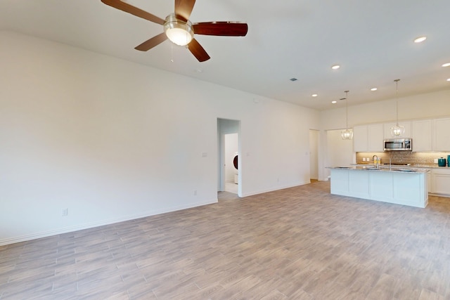5204 Edge Way, Denton, TX 76226 - unfurnished living room featuring a sink, recessed lighting, light wood-type flooring, baseboards, and ceiling fan
