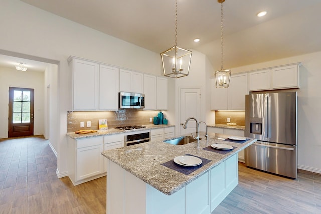 5204 Edge Way, Denton, TX 76226 - kitchen with stainless steel appliances, a sink, white cabinets, backsplash, and light wood-type flooring