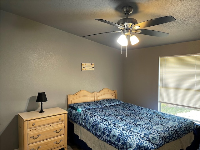 bedroom with ceiling fan and a textured ceiling