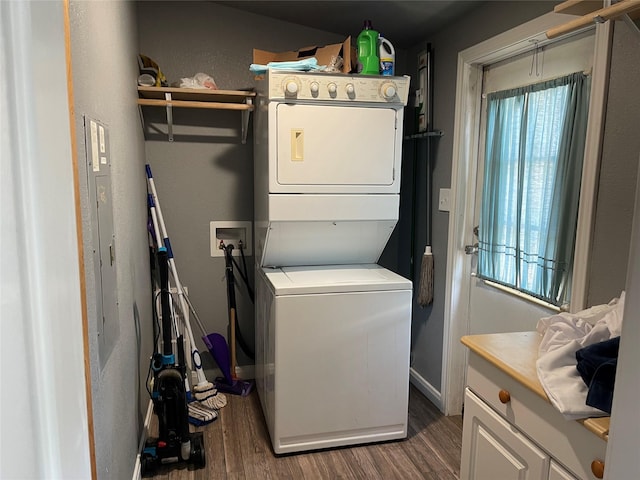 washroom with dark wood-type flooring and stacked washer and clothes dryer