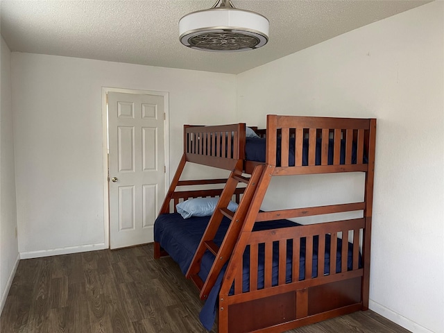 bedroom with dark hardwood / wood-style flooring and a textured ceiling