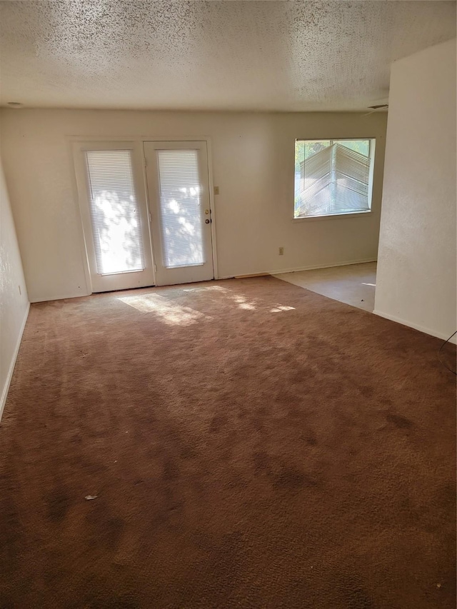 carpeted empty room with a textured ceiling