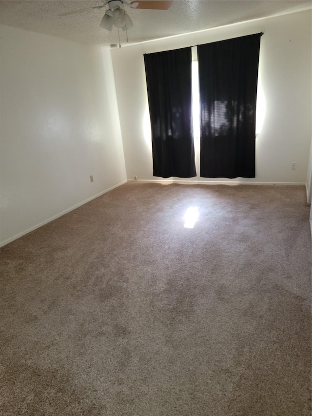 spare room featuring ceiling fan, a textured ceiling, and carpet flooring