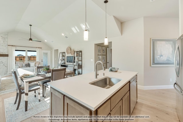 kitchen with sink, hanging light fixtures, a center island with sink, light hardwood / wood-style flooring, and stainless steel appliances