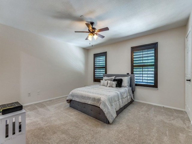 bedroom featuring multiple windows, light colored carpet, and ceiling fan