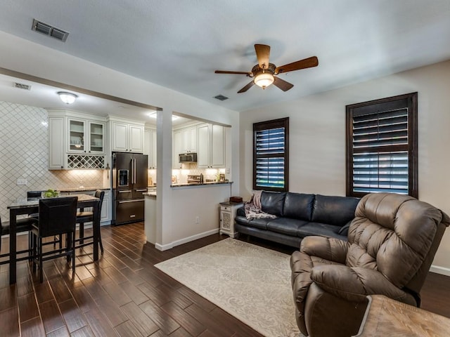 living room featuring dark wood-type flooring and ceiling fan