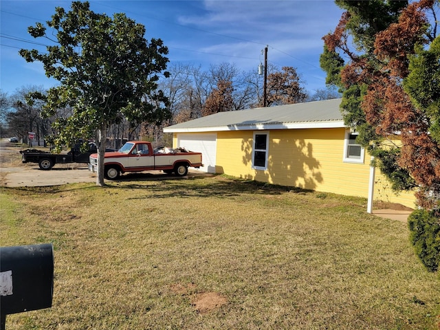 view of side of property with a yard and a garage