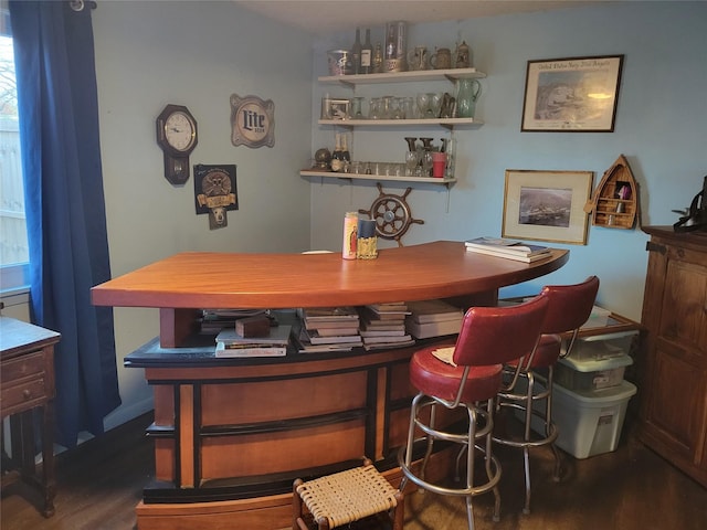 dining space with bar area and dark hardwood / wood-style flooring