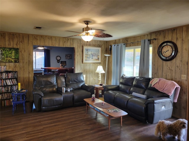 living room featuring ceiling fan, wooden walls, and dark hardwood / wood-style flooring