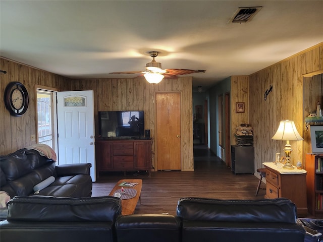 living room featuring ceiling fan, wooden walls, and dark hardwood / wood-style flooring