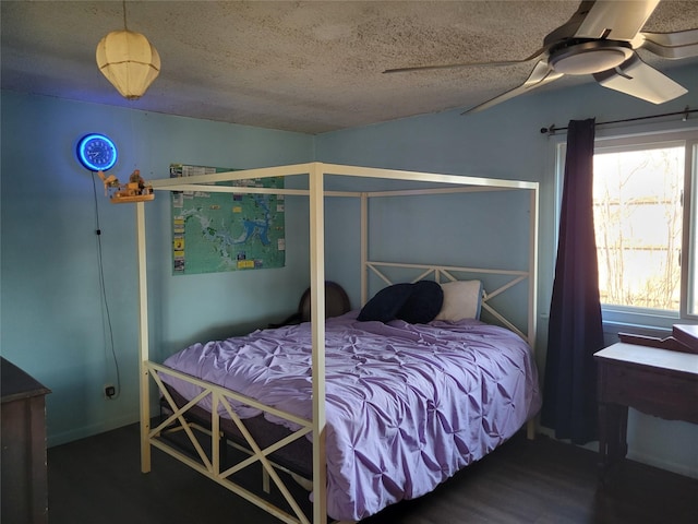 bedroom with dark wood-type flooring, ceiling fan, and a textured ceiling