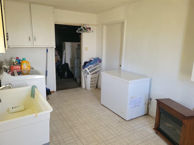 kitchen with fridge, washer and dryer, and white cabinets