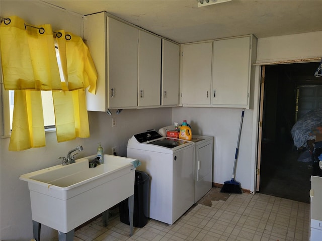 laundry area featuring sink, washer and clothes dryer, and cabinets