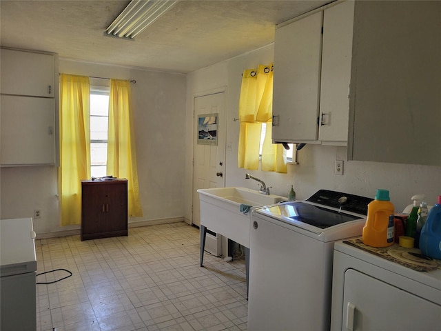 laundry area featuring cabinets, sink, and washing machine and clothes dryer