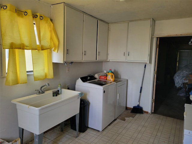 laundry area featuring cabinets, independent washer and dryer, and sink