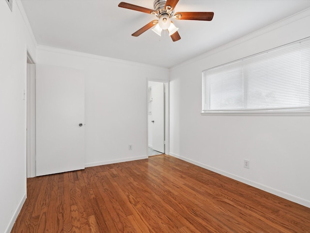 empty room with dark hardwood / wood-style flooring, ceiling fan, and crown molding