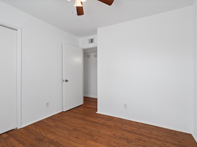 empty room featuring ceiling fan and dark wood-type flooring