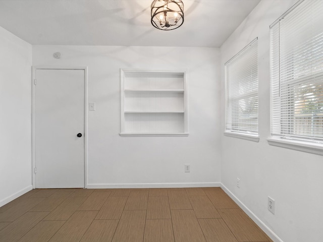 unfurnished room featuring a chandelier