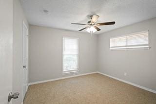 carpeted spare room featuring ceiling fan and a healthy amount of sunlight