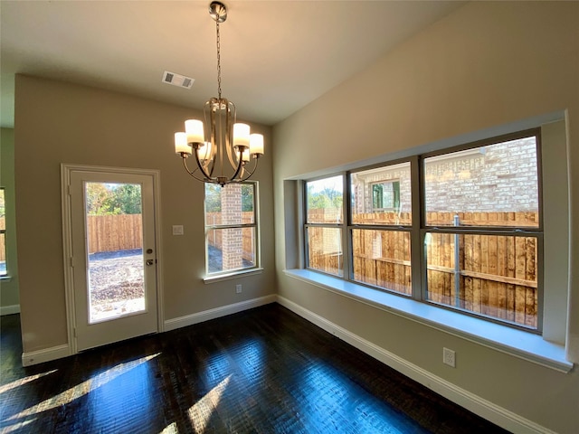 unfurnished dining area with a notable chandelier and dark hardwood / wood-style floors