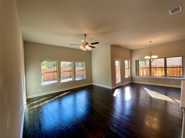 interior space featuring ceiling fan with notable chandelier, dark hardwood / wood-style flooring, and a wealth of natural light