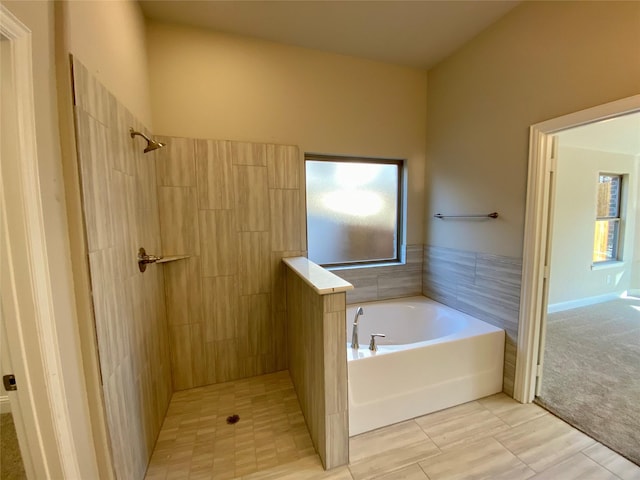 bathroom featuring a tile shower and a bath