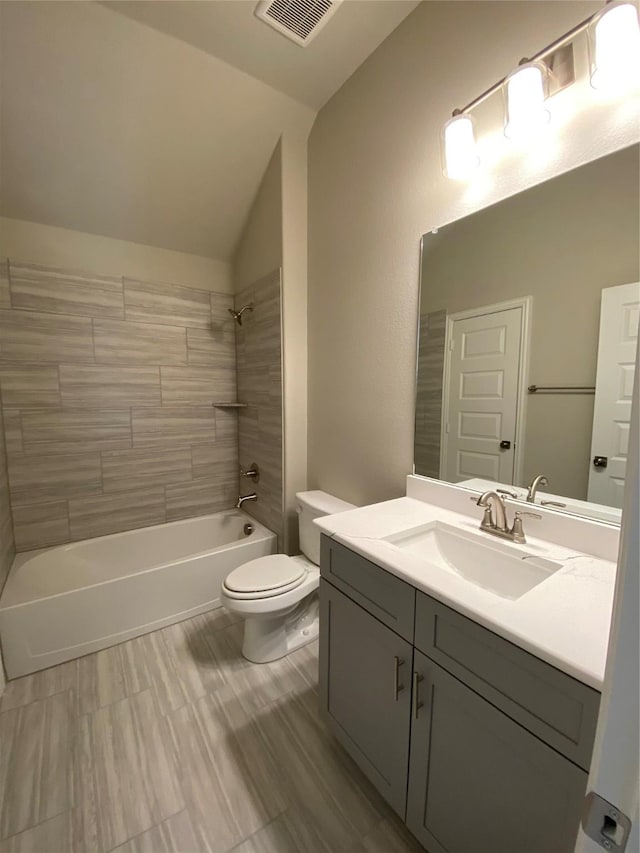 bathroom with shower / bathtub combination, lofted ceiling, toilet, vanity, and visible vents