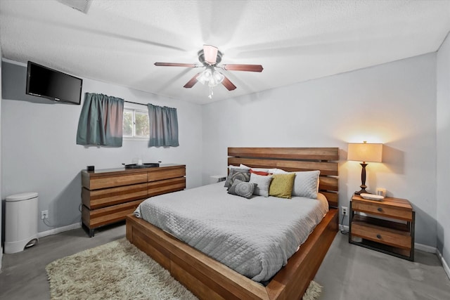 bedroom featuring ceiling fan, concrete flooring, and a textured ceiling