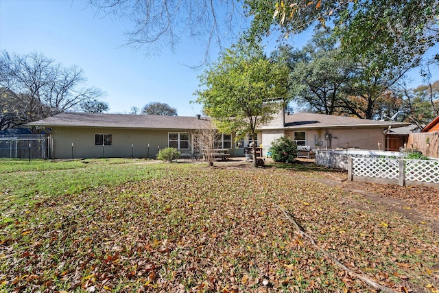 back of house featuring a lawn