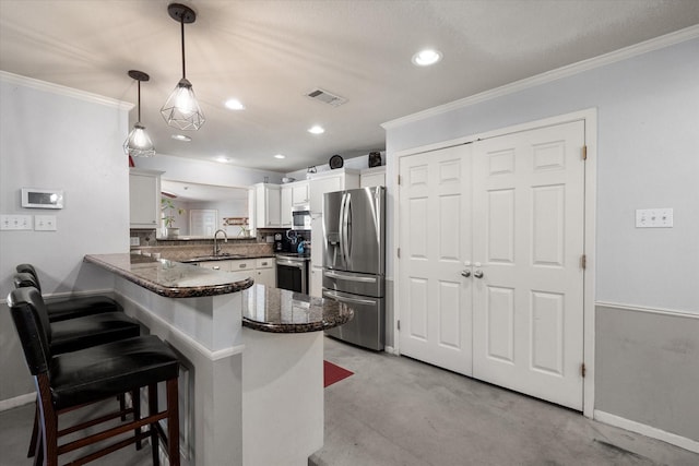 kitchen with hanging light fixtures, kitchen peninsula, a breakfast bar, white cabinets, and appliances with stainless steel finishes