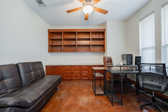 home office with concrete floors, a healthy amount of sunlight, and ceiling fan