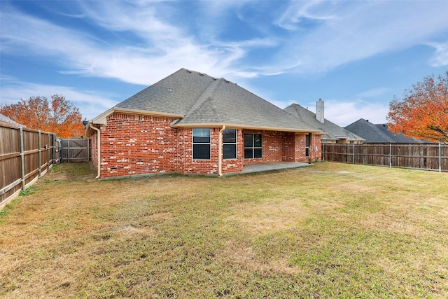 back of property with a yard and a patio