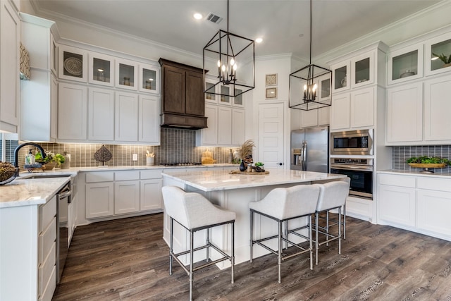 kitchen featuring white cabinetry, a kitchen island, appliances with stainless steel finishes, and a sink