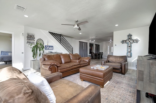 living room with a textured ceiling and ceiling fan