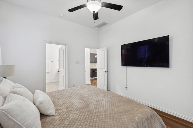 bedroom featuring ceiling fan, light hardwood / wood-style floors, and connected bathroom