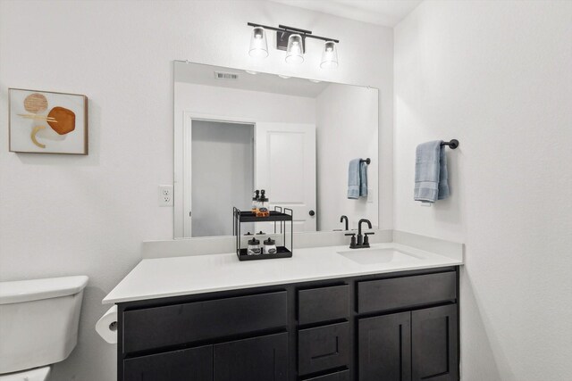 bathroom featuring vanity and toilet