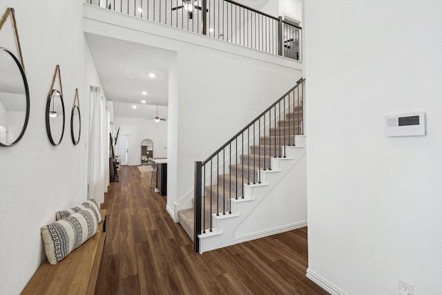 interior space featuring hardwood / wood-style floors, ceiling fan, and a high ceiling