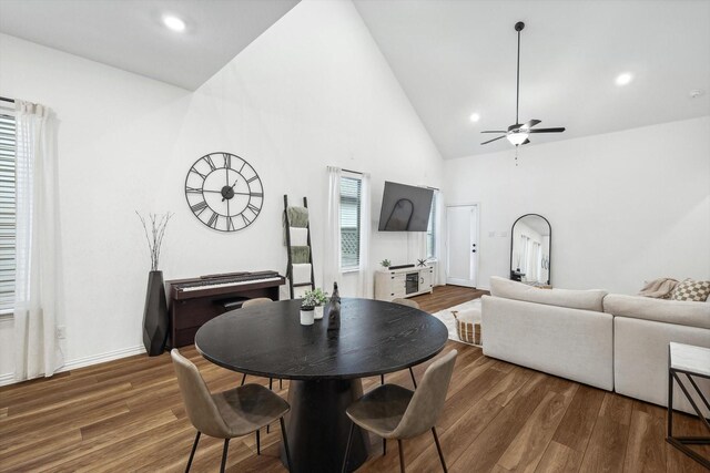 dining room featuring dark hardwood / wood-style floors, ceiling fan, and high vaulted ceiling