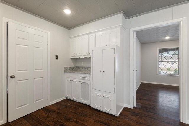 bar featuring dark hardwood / wood-style flooring, white cabinets, and ornamental molding