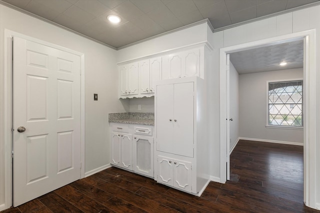 bar featuring ornamental molding, dark hardwood / wood-style floors, and white cabinets