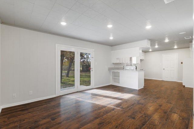 unfurnished living room with dark hardwood / wood-style flooring and ornamental molding