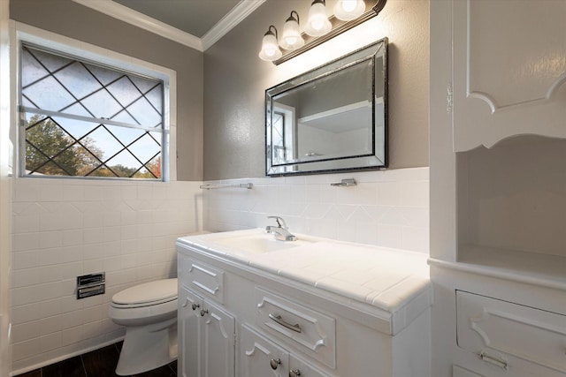 bathroom with vanity, toilet, tile walls, and crown molding