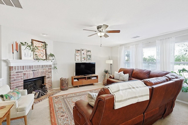 living room featuring ceiling fan, light colored carpet, and a fireplace