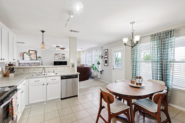 kitchen featuring stainless steel appliances, white cabinetry, hanging light fixtures, and sink