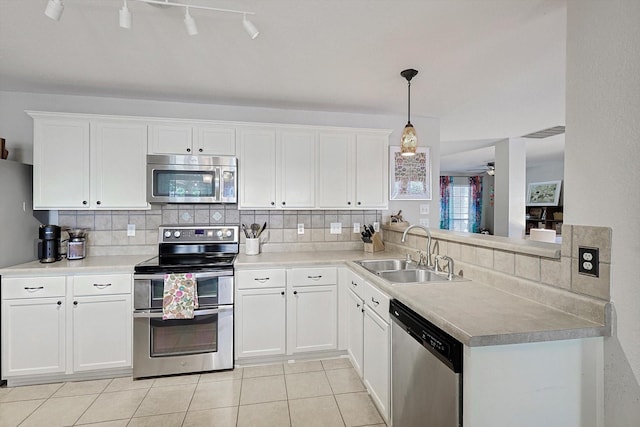 kitchen with white cabinetry, stainless steel appliances, decorative light fixtures, and sink